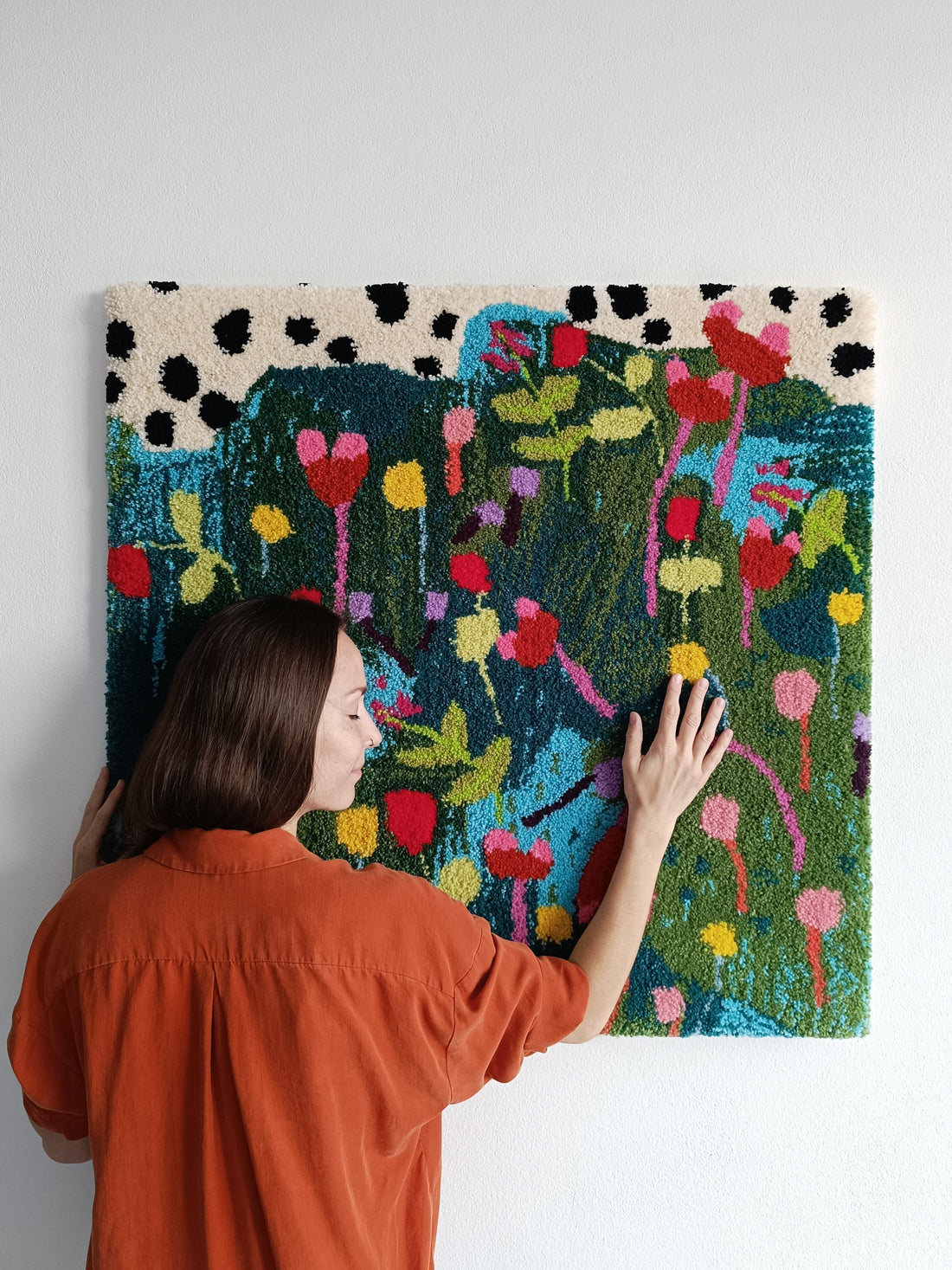 Hand-tufted wool tapestry with abstract floral design in pink and green tones