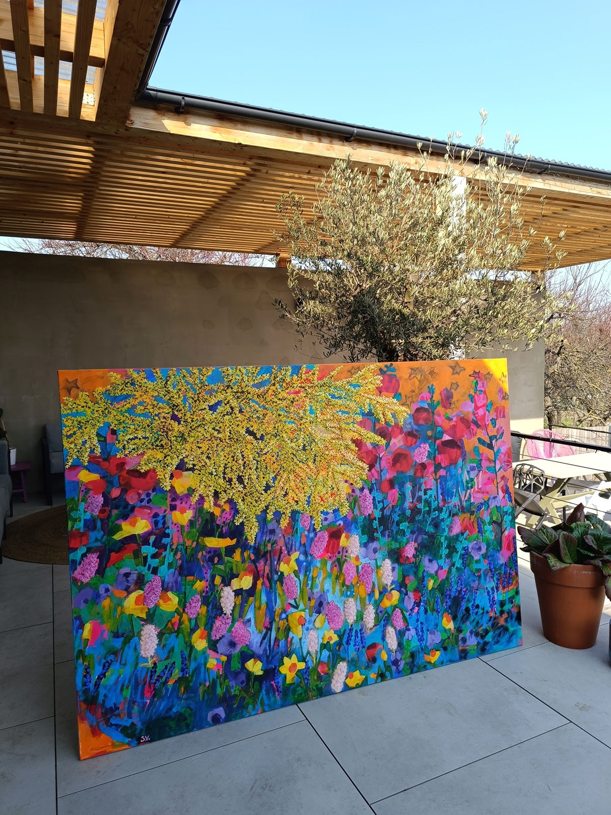 Large abstract floral canvas painting displayed outdoors showing full scale and color composition